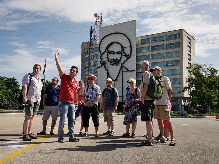 camilo cienfuegos in revolution square with his beard and many tourist in tours around cuba